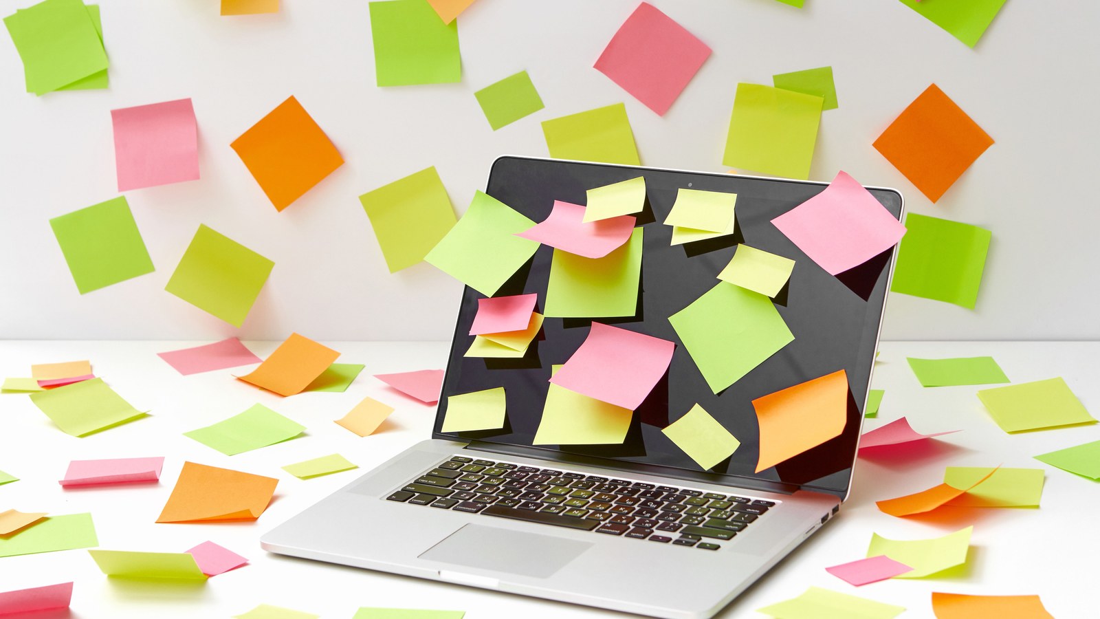 A laptop covered in scattered sticky notes, representing the overwhelm of too many ideas and no clear plan